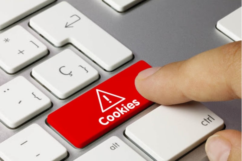 Imagem de um dedo pressionando uma tecla de computador vermelha escrito cookies