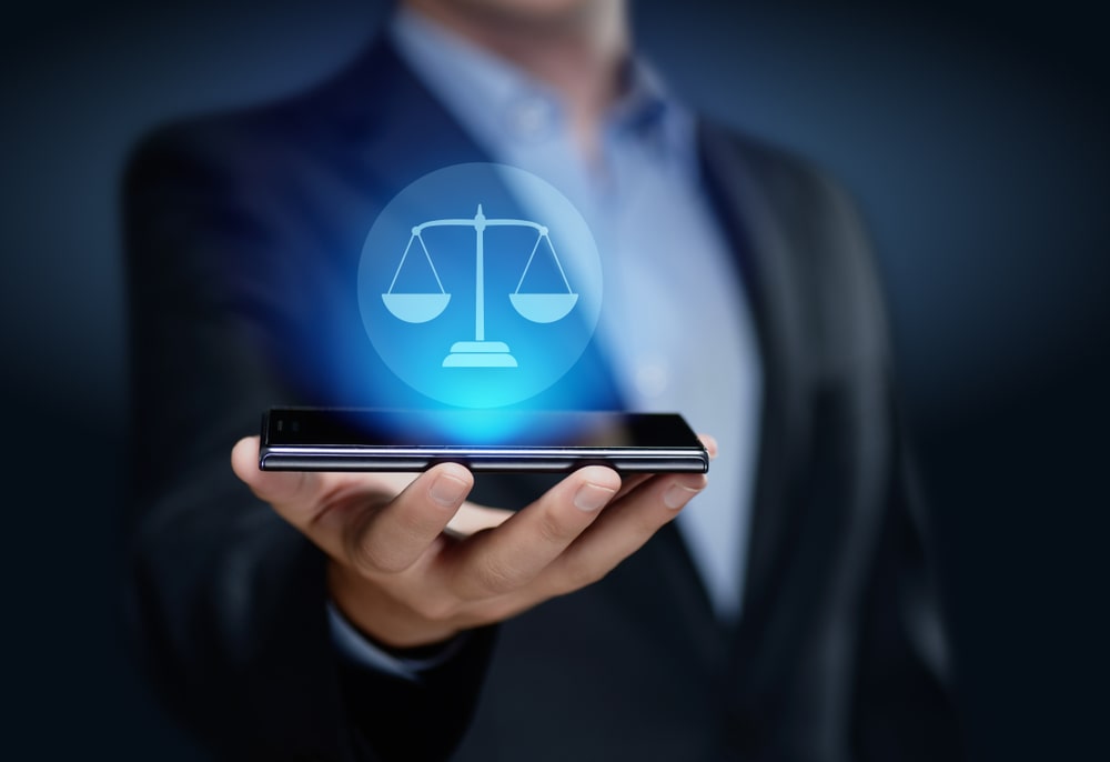 Imagem de uma balança virtual de direito sobre um celular