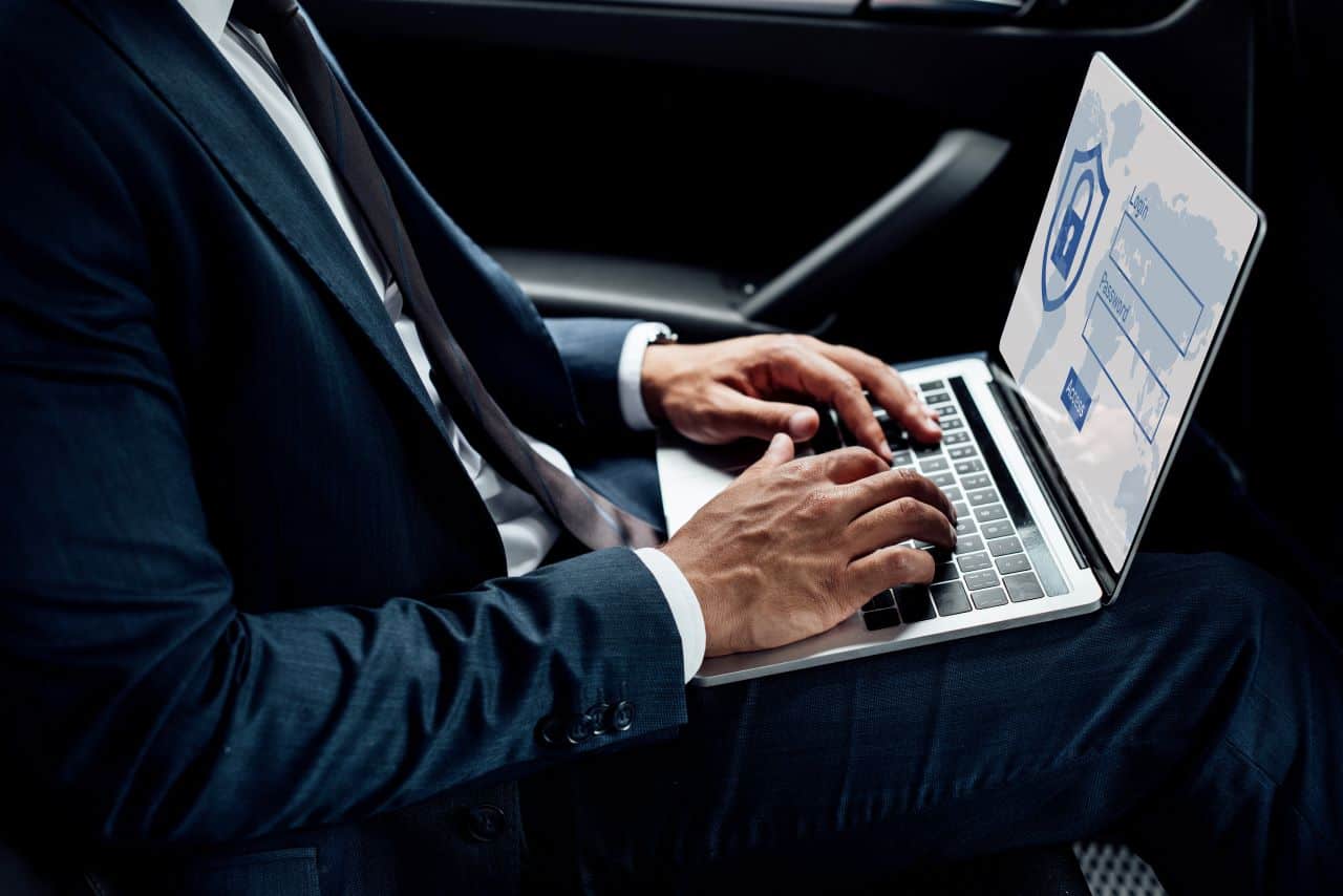 Imagem de um homem utilizando notebook dentro de um automóvel